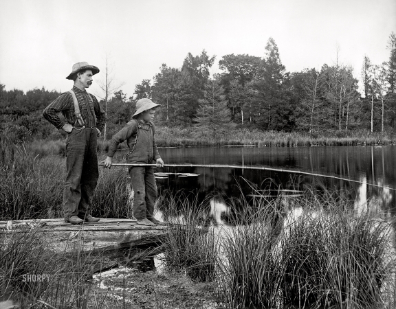 Photo showing: On Olden Pond -- Circa 1900. Man and boy fishing with cane pole from shore.