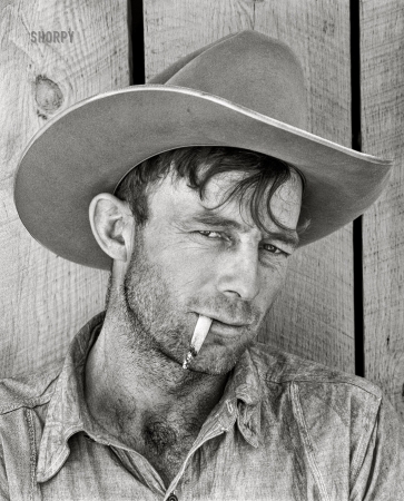 Photo showing: Smoking Cowpoke -- June 1939. Cowhand at the Quarter Circle 'U' Brewster-Arnold Ranch, Montana.