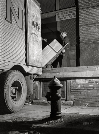 Photo showing: Night Movers -- February 1943. New York. Associated Transport terminal on Washington Street. Loading a southbound truck.