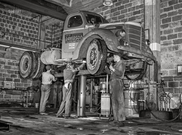 Photo showing: Fast Freight -- March 1943. Baltimore, Maryland. Davidson Transfer Company trucking terminal. Lubricating a truck tractor.