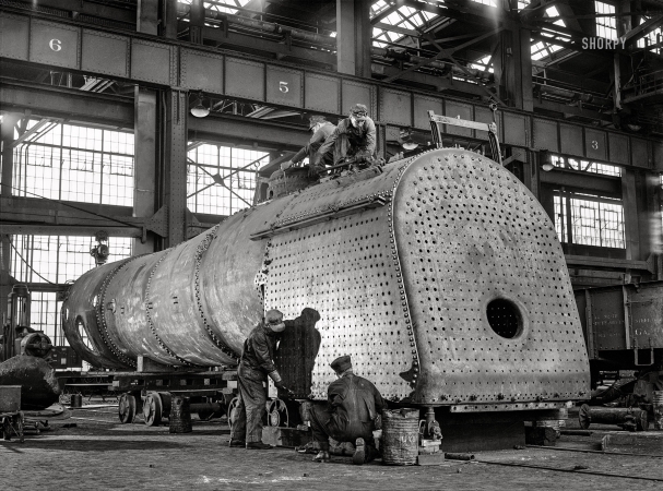 Photo showing: Fire in the Hole -- March 1943. Albuquerque, New Mexico. Working on the firebox of an engine in the Santa Fe locomotive shops.